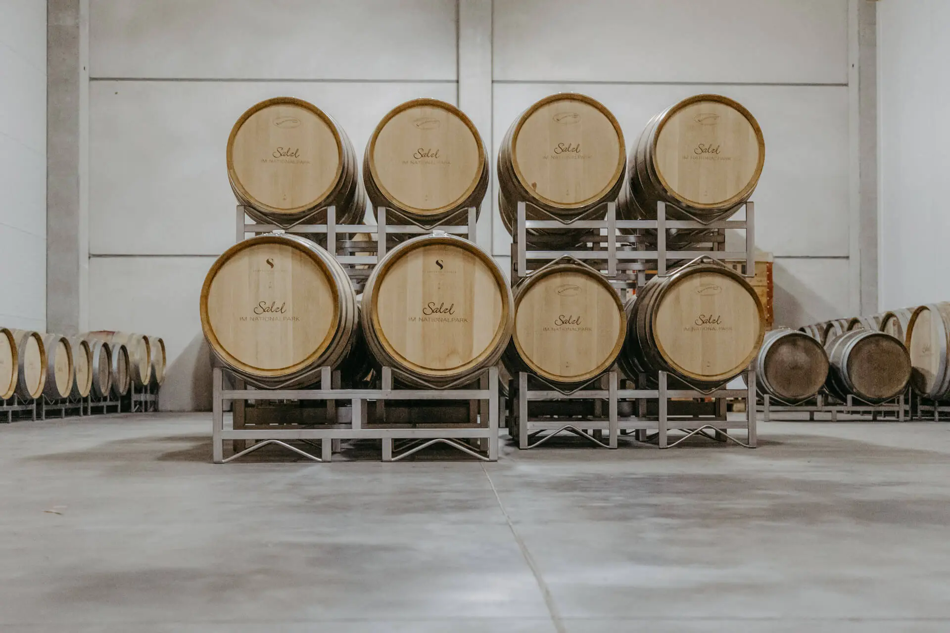 Gelagerte Weinfässer in einer großen Weinlagerhalle vom Weingut Salzl
